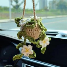 a crocheted flower hanging from the dashboard of a car