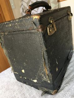 an old suitcase sitting on top of a bed