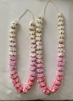 three pink and white flower leis on a table