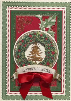 a christmas card with a wreath and holly on the front, red ribbon around it