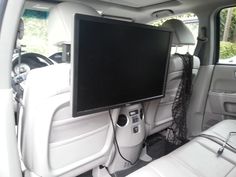 the interior of a car with a flat screen tv mounted to the back of it