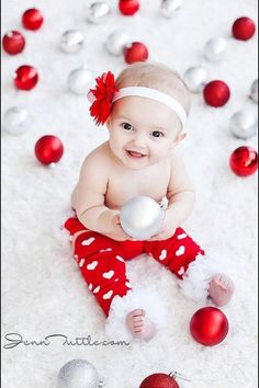 a baby is sitting on the floor with ornaments around her