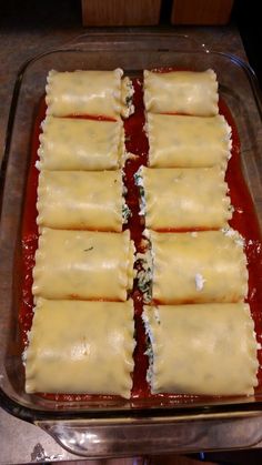 several pieces of ravioli sitting on top of a pan covered in sauce and cheese