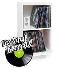 the vinyl records are stacked on top of each other in a white shelf with green and black stickers