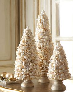 three white christmas trees sitting on top of a table