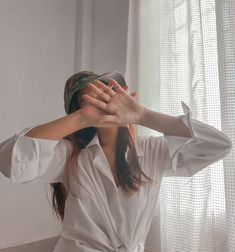 a woman is covering her eyes with her hands