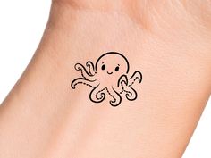 an octopus tattoo on the wrist is shown in black ink, and it appears to be drawn