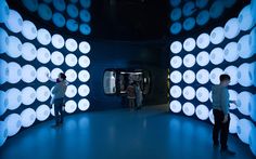 two people are standing in front of an art installation that looks like circles and dots