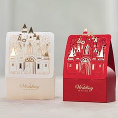 two red and white boxes with paper cut designs on the front one has a castle in it