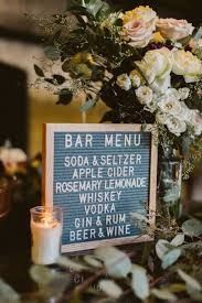 a sign that says bar menu sitting on top of a table next to some flowers