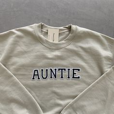 This unique and trendy beige Auntie sweatshirt is perfect for lounging in this cozy fall season! This is also perfect for gifting to your loved ones! The letters (patches) and are heat pressed. Our sweatshirts run in a UNISEX fit. The sweaters naturally have a slightly oversized fit giving extra room for moving around and comfort! For this reason, we highly recommend getting your true normal size especially if you like that slight oversized fit! :) We are currently offering sizes S-L. The materi Sibling Pregnancy Announcement, Aunt Sweater, Auntie Sweatshirt, Aunt Baby, Pregnancy Announcement Sibling, Baby Aunt, Aunt Sweatshirt, Mom Dad Baby, Mini Outfit