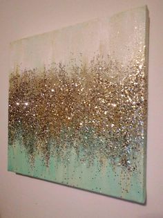 a painting with gold and silver glitters on it hanging on a wall next to a toilet