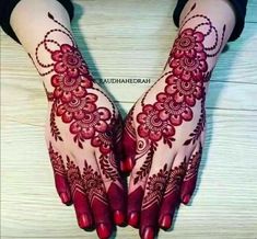 a woman's hands with henna tattoos on them