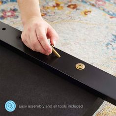 a person using a tool to attach a piece of furniture on top of a rug