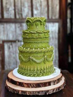 a green wedding cake sitting on top of a wooden table