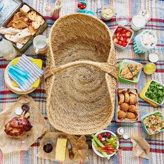 a picnic table filled with food and drinks on top of a checkered table cloth