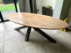 a wooden table sitting on top of a tile floor next to a sliding glass door