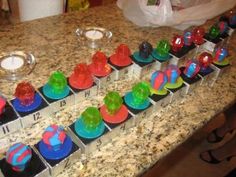 there are many colorful cupcakes on the counter top, with numbers and letters