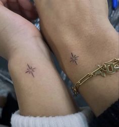 two people with matching tattoos on their arms, one is holding the other's arm