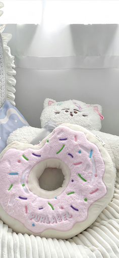 two stuffed animals sitting next to each other on top of a white bed with donuts