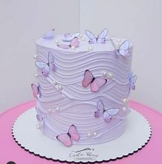 there is a white cake with pink butterflies on it