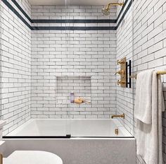 a white bathroom with black and gold accents