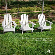 two white adiron chairs sitting on top of a green grass covered field next to each other