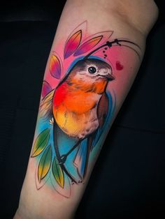 a colorful bird tattoo on the arm