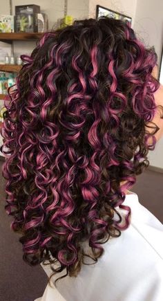 the back of a woman's head with purple and black curly hair in it