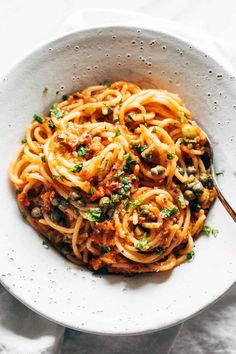 a white bowl filled with pasta and sauce