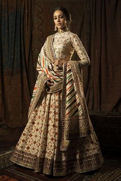 Ivory lehenga with patola printed motifs highlighted in Kutch work, gotta and sequin embroidered borders. Paired with a geometric gotta pattern blouse with a keyhole back and  a chevron dupatta with gotta and borders with Kutch embroidery.
Component: 3
Pattern: Printed, Embroidered
Type Of Work: Gota, Resham with Golden Zari and Sequins Border 
Neckline: Round
Sleeve Type: Long Sleeves
Fabric: Silk
Color: White
Other Details: 
Patola print
Striped dupatta
Kutch work
Occasion: Sangeet, Destinatio Mayyur Girotra, Ivory Lehenga, Patola Print, Orange Lehenga, Print Lehenga, Bridal Wardrobe, Lehenga Pattern, Wedding Outfits For Women, Kutch Work