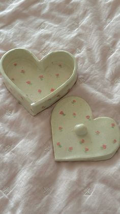 two heart shaped dishes sitting on top of a bed