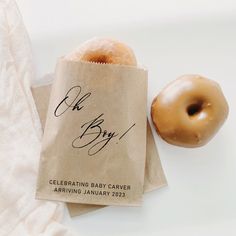 a baby shower bag next to a donut on a white surface with the words, celebrating baby cauver arrival january 2013