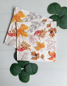 two napkins with leaves and berries on them