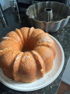 a bundt cake sitting on top of a white plate next to a metal pan