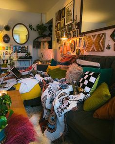 a living room filled with lots of furniture and pictures on the wall next to a coffee table