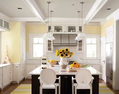 a kitchen with sunflowers on the table and two chairs in front of it