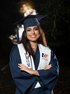 a woman wearing a graduation cap and gown with her arms crossed in front of her