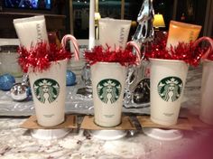 three starbucks cups with candy canes in them