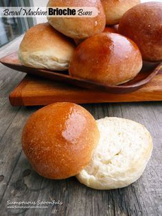 bread rolls sitting on top of a wooden cutting board