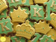 decorated cookies in the shape of crowns are displayed on a wooden table with green and yellow icing