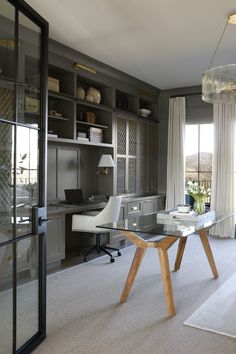 a glass table in the middle of a room with shelves on either side and a chair at the end