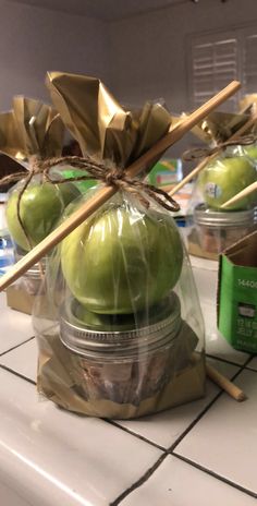 some apples wrapped in plastic sitting on top of a counter