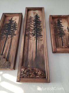 three wooden trays with trees painted on the sides and rocks in front of them