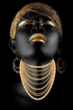 a woman's face with gold jewelry on her neck and eyes covered in black