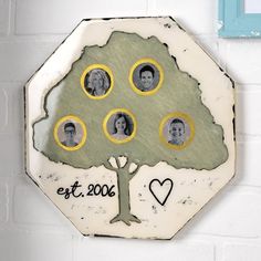 a family tree with four people in the center and two hearts on each side, hanging on a wall