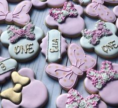 some decorated cookies are sitting on a table with other ones in the shape of minnie mouses