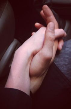 two people holding hands while sitting down