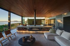 a living room with couches and tables on the floor next to an ocean view