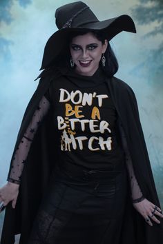 a woman wearing a black shirt with the words don't be a better witch on it